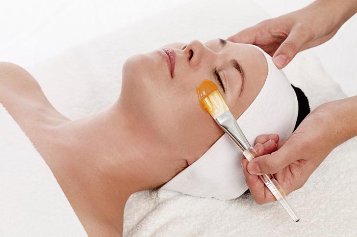 Woman pampering herself with a facial using a brush