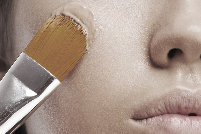 Woman applying foundation with a brush