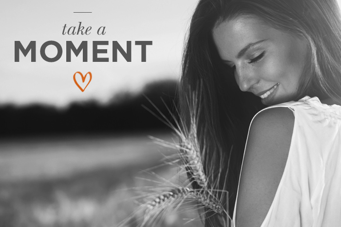 Black and white image, lady looking down over her shoulder, with the caption take a moment