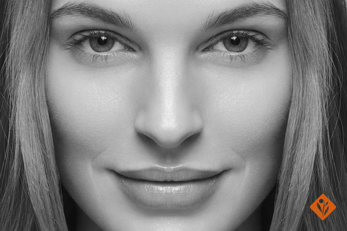 Black and white image of a woman smiling with beautiful skin