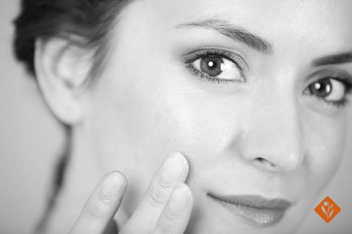 Black and white image of a woman touching her face
