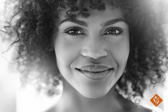 Black and white image of a lady with curly hair smiling at camera