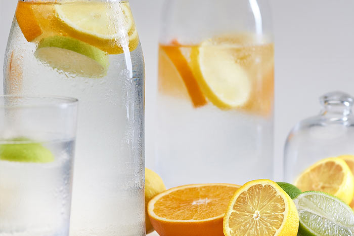 Glass bottles with water and lemon and orange slices for skin care