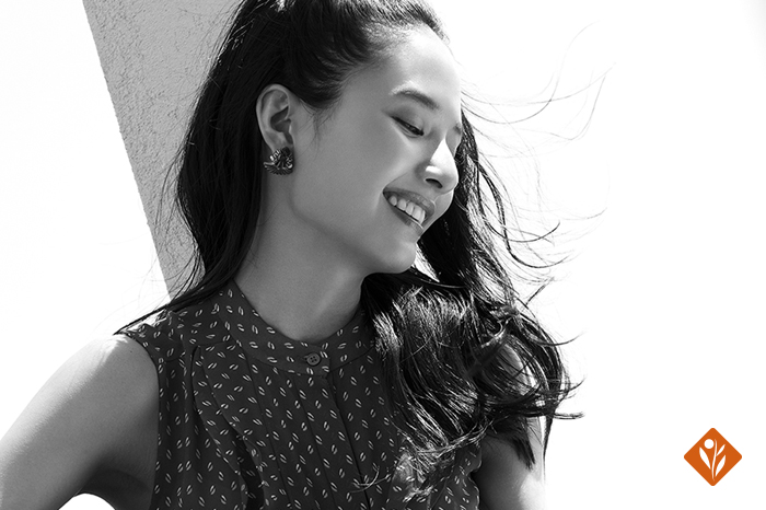 Black and white, woman with open hair, looking down and smiling